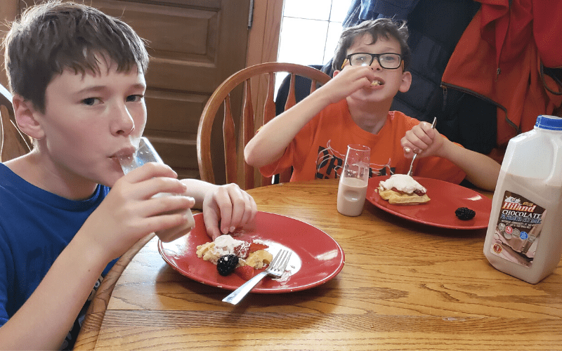 Kids enjoying butttermilk waffles and chocolate milk at table