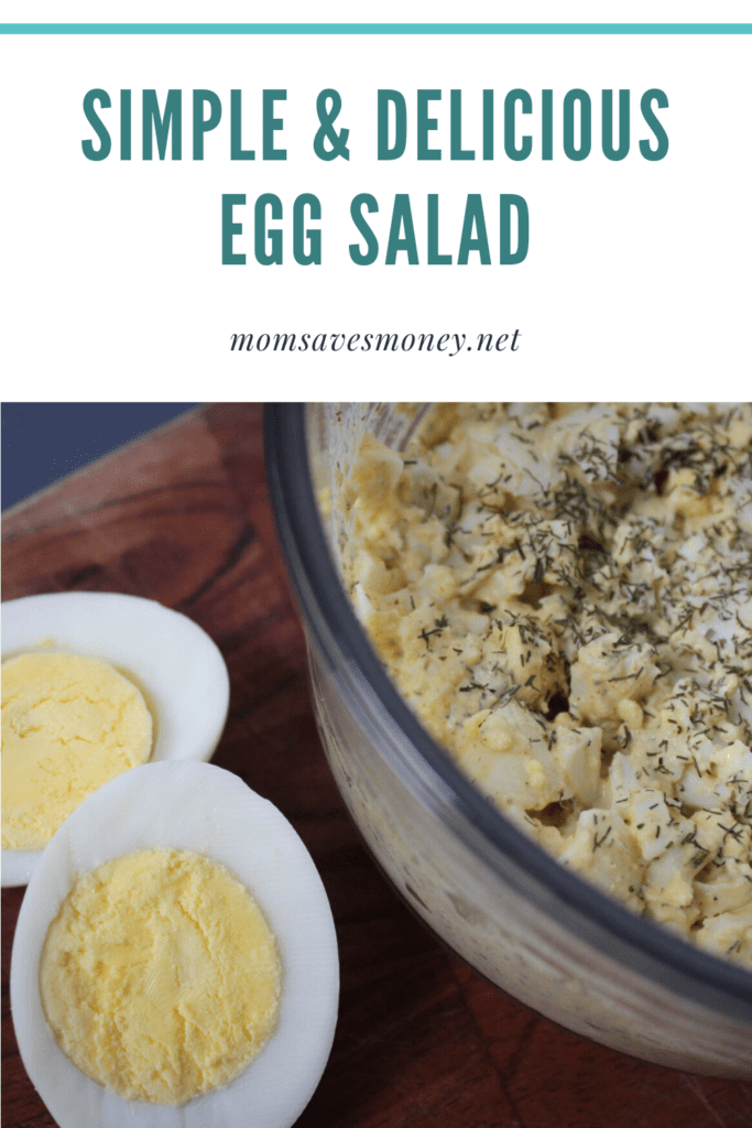 Egg salad in a bowl next to a sliced hard boiled egg