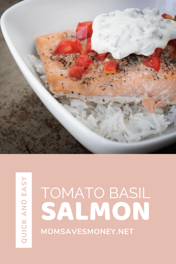 Baked salmon with tomatoes and basil mayo sauce over rice in a white bowl