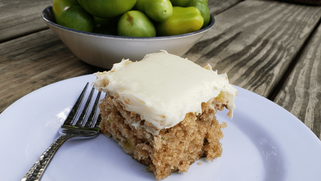 green tomato cake with cream cheese frosting on a white plate