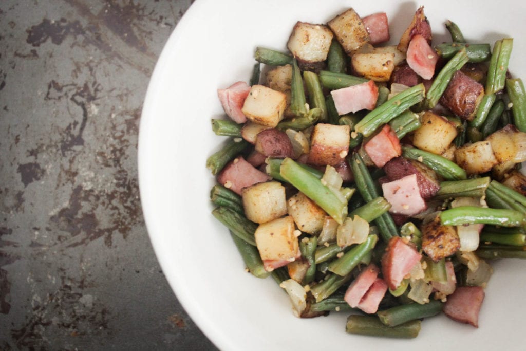 Baked ham potatoes and green beans in a white bowl