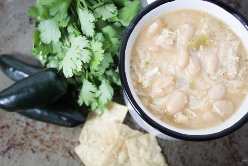 White chicken chili in bowl with tortilla chips