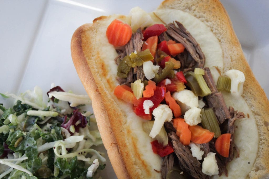 Hot Italian beef sandwiches with provolone cheese and Giardiniera served with a side salad