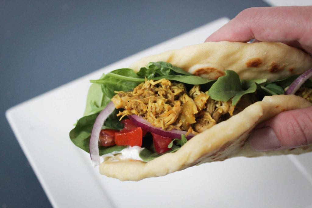 Crock Pot chicken shawarma served in naan bread with mixed greens, diced tomatoes, red onion and tzatziki sauce