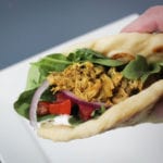 Crock Pot chicken shawarma served in naan bread with mixed greens, diced tomatoes, red onion and tzatziki sauce