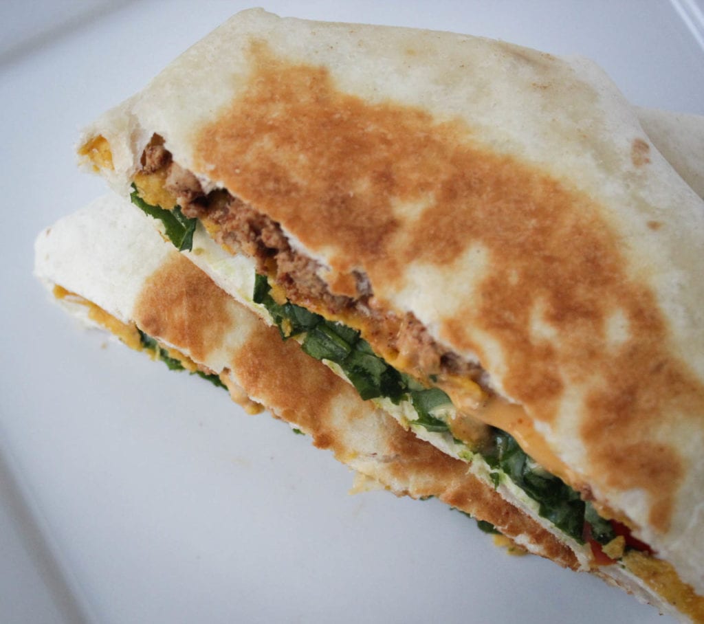 Copycat crunchwrap supreme recipe with 7 ingredients - tortilla shells, taco meat, sour cream, cheese sauce, tostadas, lettuce and tomatoes