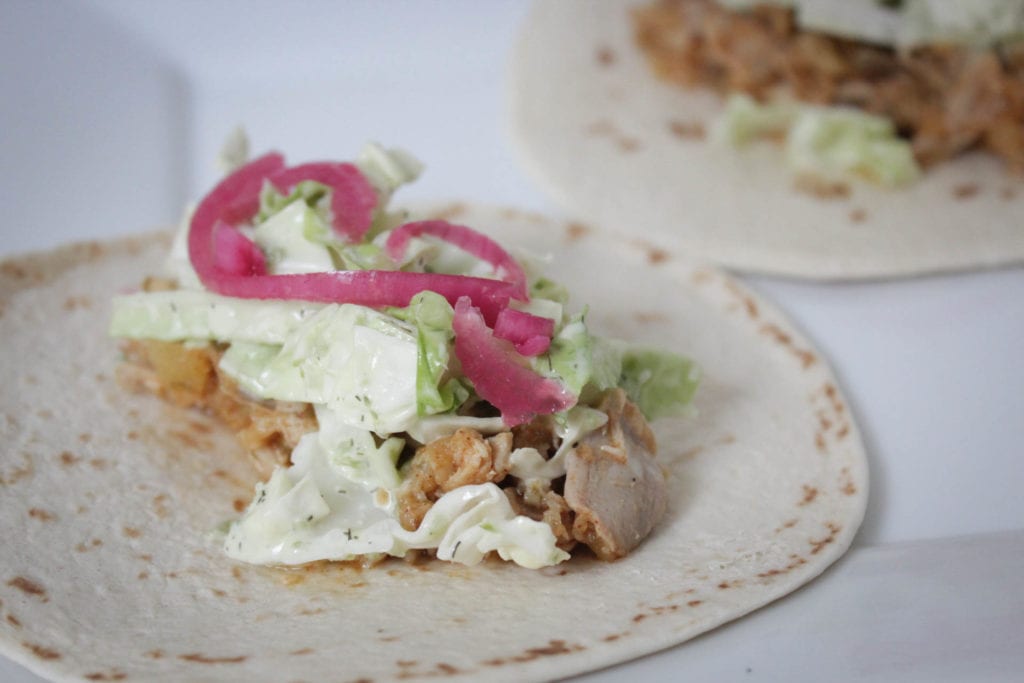 Tortilla shell with slow cooked chicken, spicy slaw, pickled red onion and cabbage