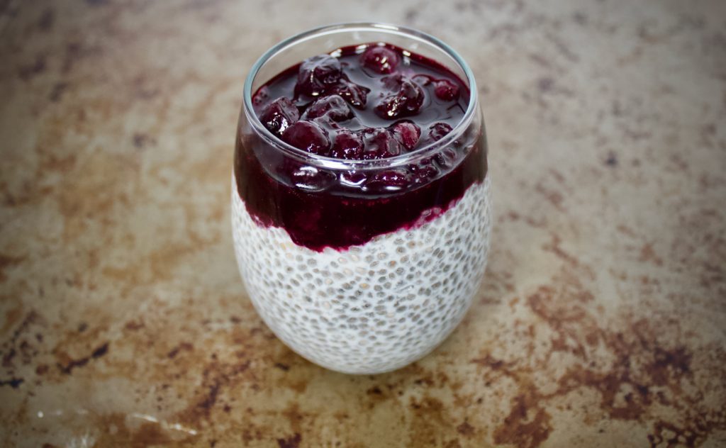 blueberry chia seed pudding in a clear glass cup