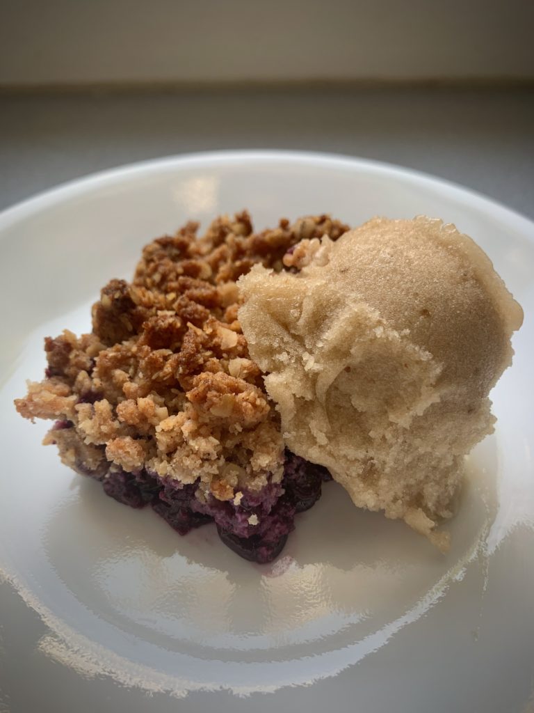 Plate with blueberry rhubarb crisp and scoop of ice cream