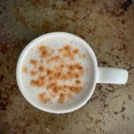 Latte in white mug spinkled with cinnamon