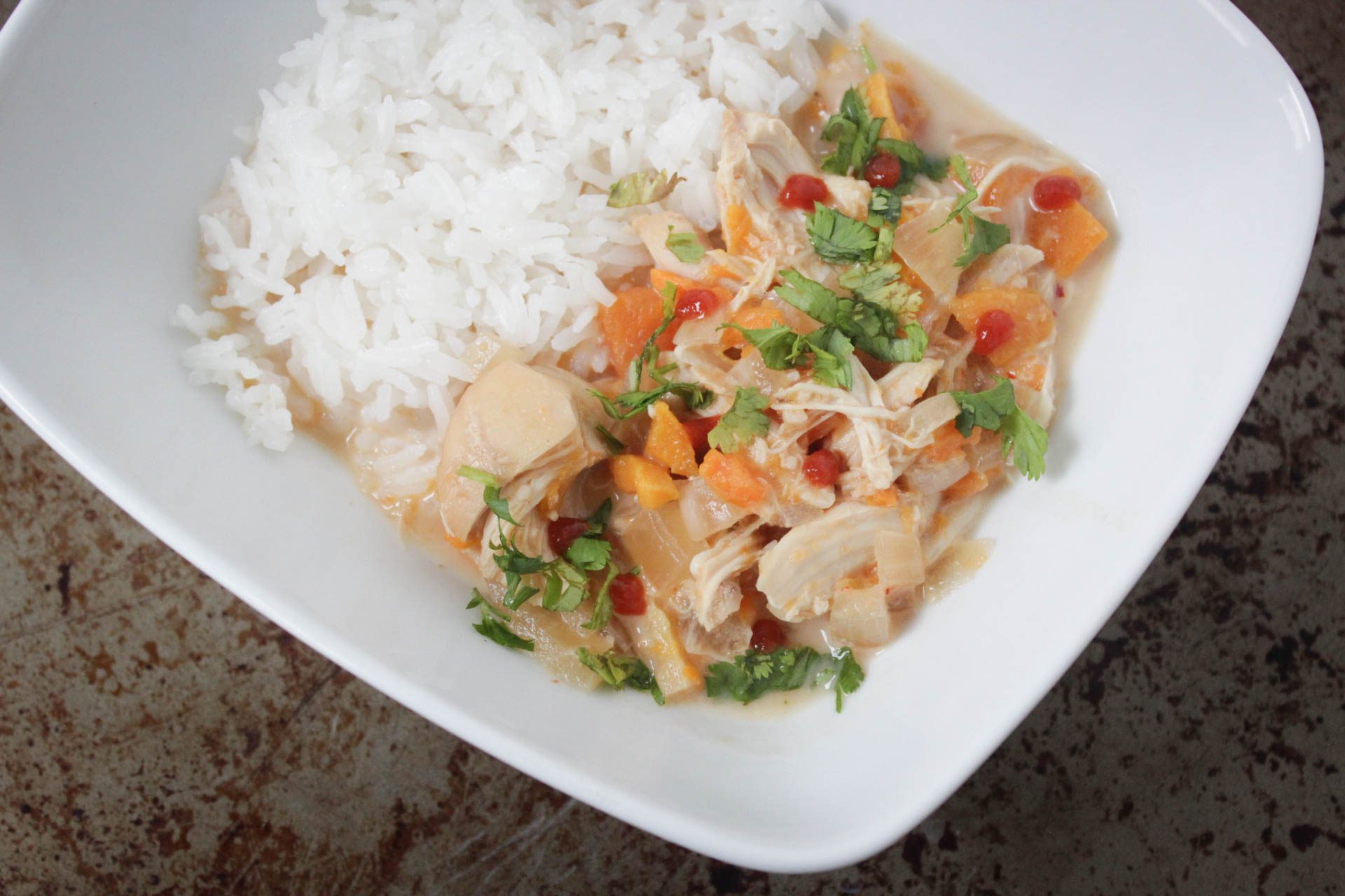 White rice with thai coconut curry chicken in white bowl