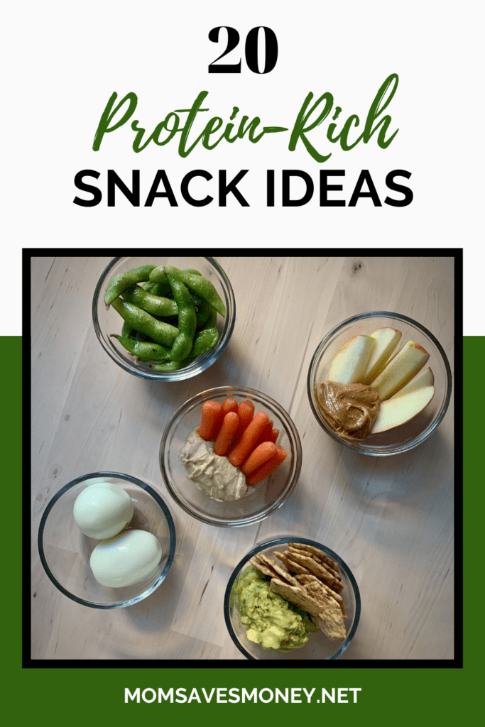 5 clear glass bowls with high-protein snacks including steamed edamame, apples with peanut butter, whole wheat crackers with guacamole, carrots with hummus and hard boiled eggs