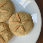 3 sand dollar almond cookies on a white plate