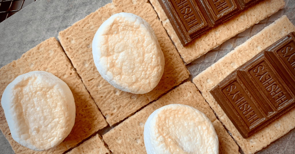 Graham crackers with toasted marshmallows and chocolate on an air fryer tray